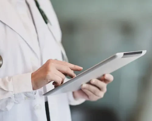 Cropped shot of young female doctor summarises patient charts with digital tablet in her office room